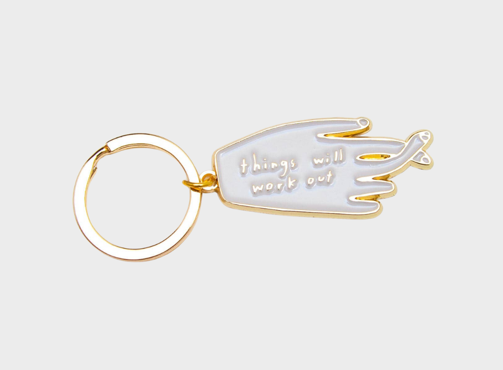 Keyring in the shape of a hand with its fingers crossed. 'Things will work out' is written  on the hand.