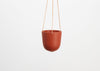 CAPRA DESIGNS HANGING PLANTER - TERRACOTTA IS SKILLFULLY HAND MADE FROM RESIN AND FINISHED WITH TAN LEATHER. Each planter has a hole in the bottom for drainage and a plug for convenience. Worldwide shipping. Free UK shipping.