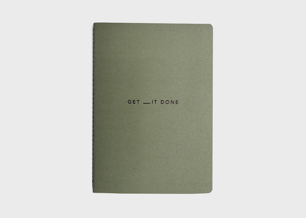 MiGoals Get It Done motivational notebook in yellow and black on a grey background. A versatile notebook designed to motivate you.