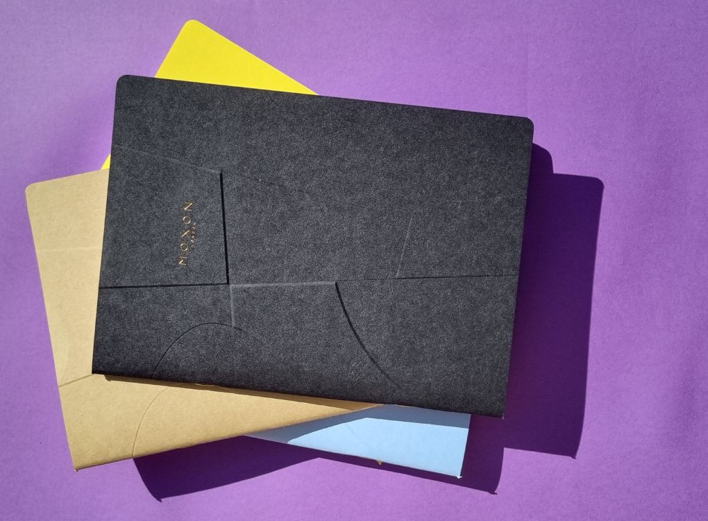 Stack of MOXON B5 ‘Form’ notebooks in mixed colours arranged diagonally on a purple background
