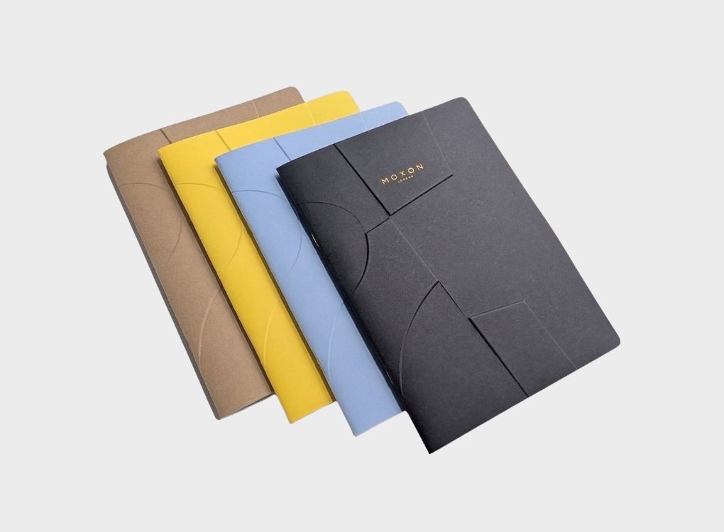 Set of MOXON B5 ‘Form’ notebooks in black, blue, yellow, and kraft arranged in a fan layout