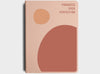 MiGoals 2026 Classic Diary in blush pink with abstract shapes in terracotta and peach, featuring the phrase “Progress Over Perfection” embossed in the top right corner.