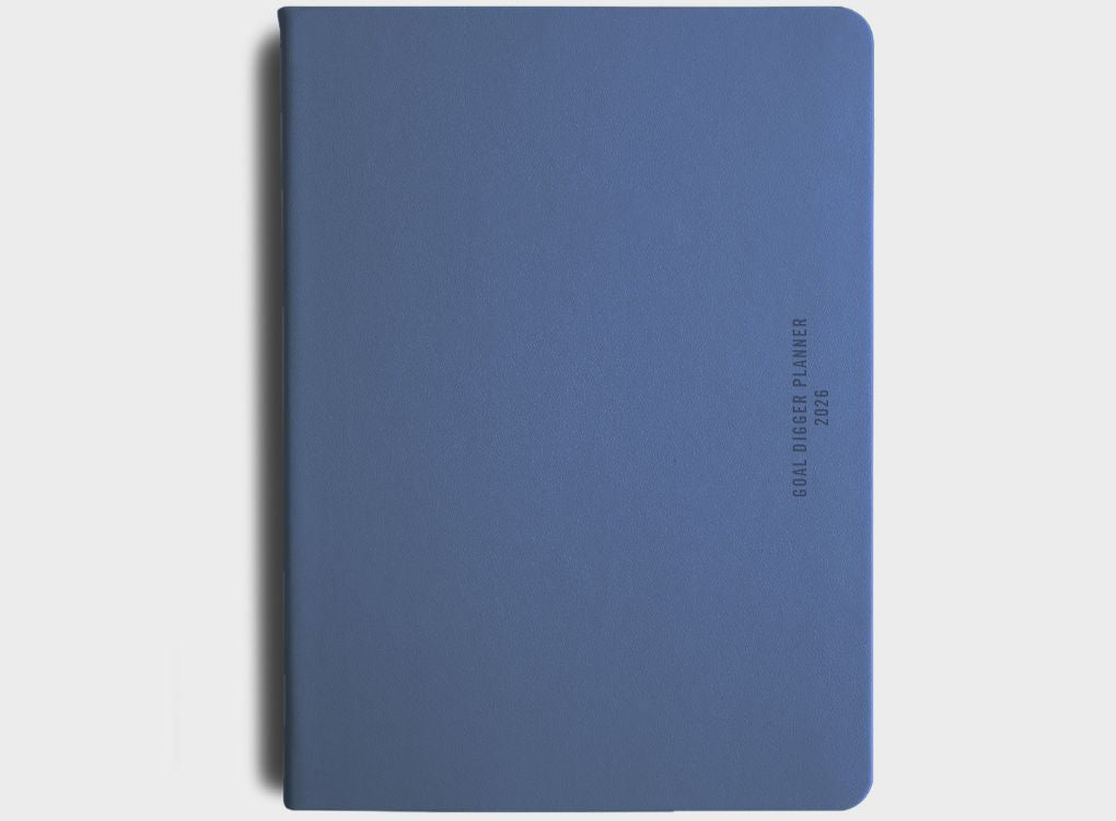 2026 Daily Goal Digger Diary in Progress over perfection. White cover with abstract shapes against a soft natural background.