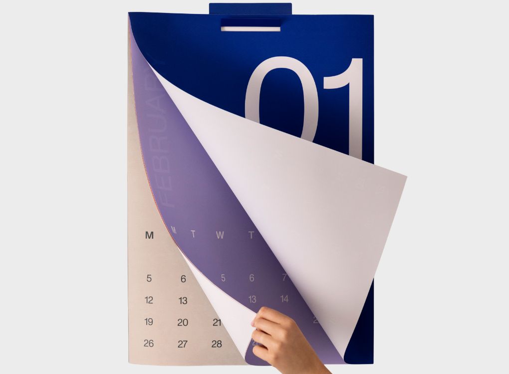 Close-up of Karst 2026 A2 Monthly Calendar with a hand lifting the page from January to February, highlighting the oversized date design and clean layout.