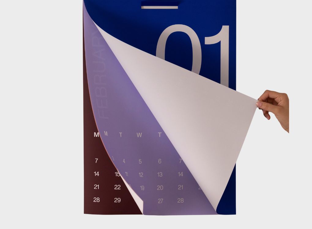 Karst 2026 A2 Monthly Calendar with a hand turning the page from January to February, showing large bold typography and minimalist design.