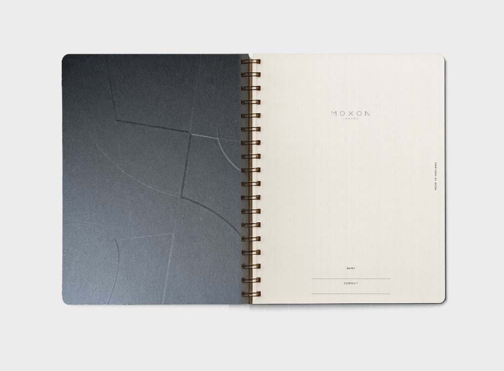 Opening page of MOXON form B5 notebook in Navy. Wirebound notebook with gold foil details. Made using recycled paper.