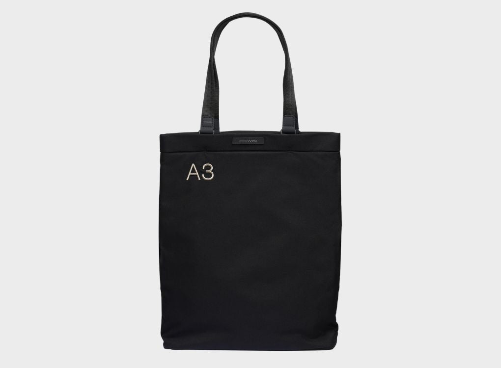 A3 Black Ash Tote Bag being displayed on a grey background.
