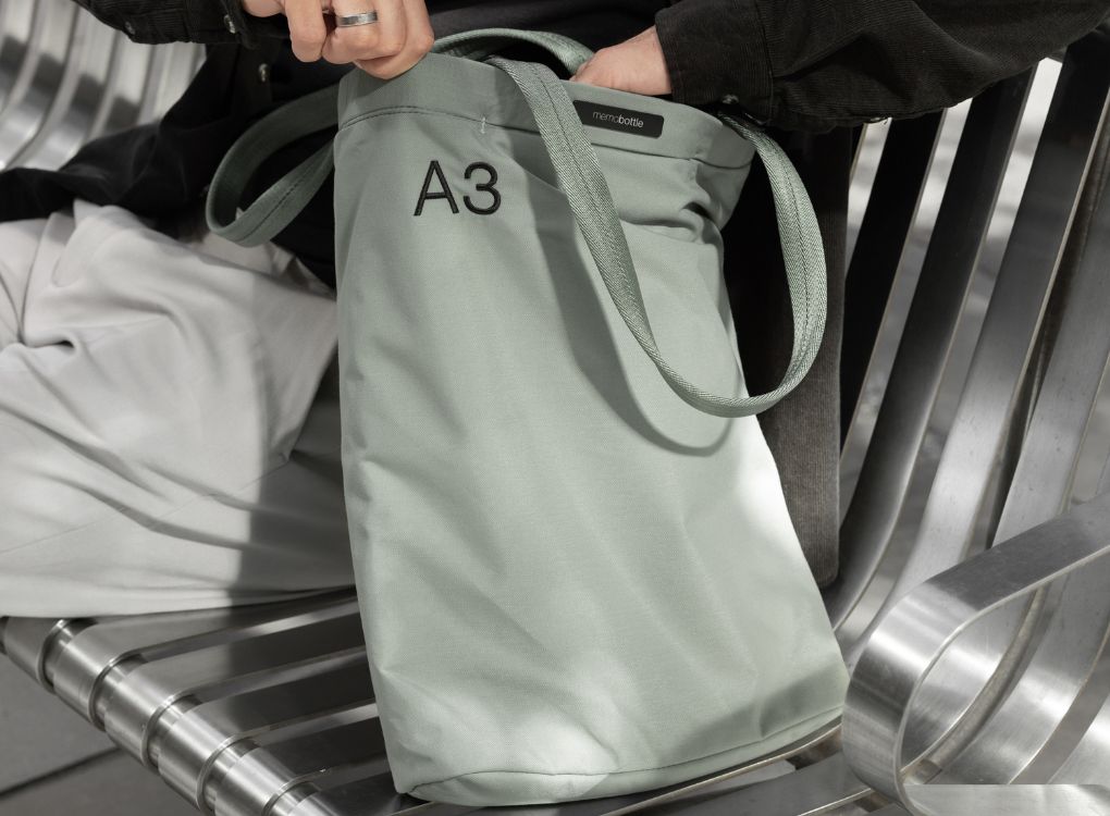 Man reaching into A3 Eucalypt Tote Bag, feeling for items with his hand.