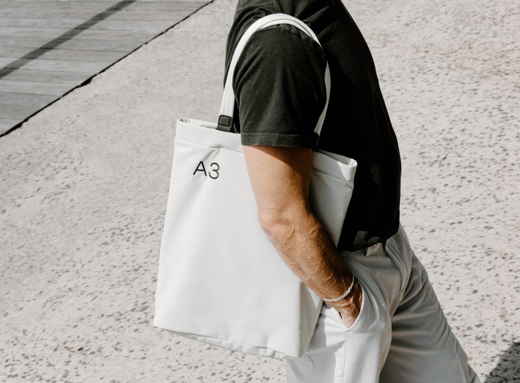 Man walking with Paperbark A3 Tote Bag over shoulder.