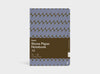 A Studio Muse A5 hardcover notebook by Karst with a blue and brown abstract checkerboard patterned cover, shown against a plain white background. The notebook has smooth, recycled stone paper with lined pages and a slim, lightweight cover.
