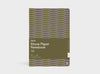 A Studio Muse A5 hardcover notebook by Karst with an olive green and lavender geometric patterned cover, shown against a plain white background. The notebook features smooth, recycled stone paper with lined pages and a slim, lightweight cover.