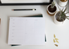 Appointed&#39;s weekly task pad, with a pencil and a cactus. The sheet has lists and days of the week on it.