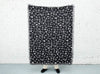 areaware cairo throw being held up by a person to show the size of it - 150cm lby 75cm, useful from blanket to sofa cover to picnic rug