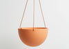 The DESERT  BLOCK COLOR DOME HANGING PLANTER IS SKILLFULLY HAND MADE FROM RESIN AND FINISHED WITH TAN LEATHER The planter has a hole in the bottom for drainage and a plug for convenience. Designed in Australia. Worldwide shipping. Free UK shipping.