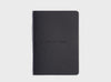 MiGoals Get It Done motivational notebook in black on a grey background. A versatile notebook designed to motivate you.