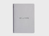 MiGoals Get It Done motivational notebook in light grey and black on a grey background. A versatile notebook designed to motivate you.