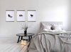 moxon magnetic frames with 3 prints hung up, next to a bed in a modern minimal contemporary bedroom