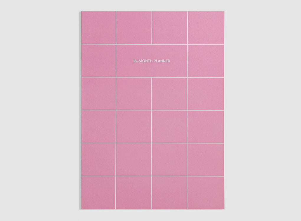 Poketo 18 month undated planner with weekly spread in bright pink, with a white grid pattern and white text, on a grey background. Smart, versatile stationery